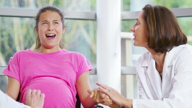  Pregnant woman going into labour concentrates on her breathing