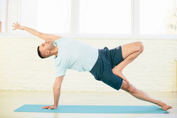 Handsome yoga man practice in a training hall background. Yoga concept.