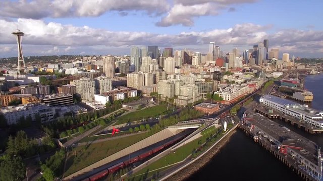 Aerial Flight Over Downtown Seattle Waterfront with City Buildings and Train