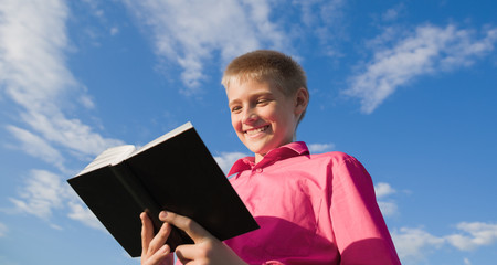 The beautiful boy reads the book