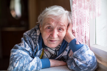 Closeup portrait of elderly woman sitting at the table.