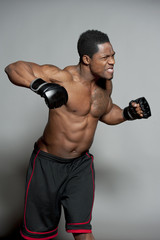Fototapeta na wymiar African American male boxing on Gray