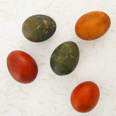 Easter eggs colored with natural onion and cabbage dye on marble background