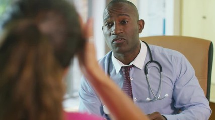  Friendly doctor talking to upset or depressed patient in office - Powered by Adobe