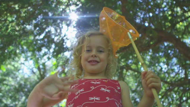 Happy little girl playing in the woods with fishing net