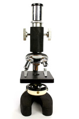 An old fashioned three turret student microscope with a white background