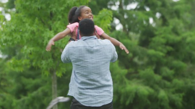 Happy African American father & daughter having fun in the park. 