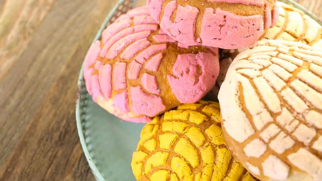 Homemade pan dulche with white, yellow, and pink icing