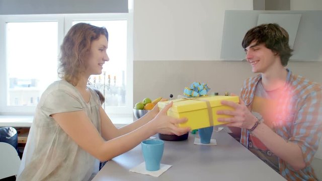 girl surprising her friend with a gift on birthday