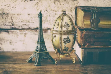  image of feberge egg, decorative eiffel tower and vintage books © tomertu