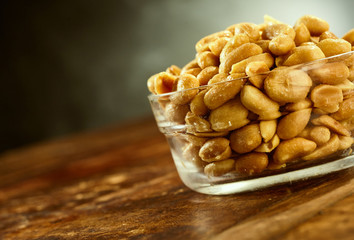 Bowl full of salty peeled oily roasted peanuts