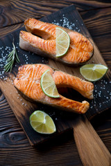Close-up of two pan fried trout steaks with sea salt and lime
