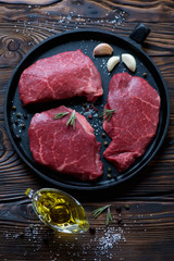 Frying pan with raw seasoned black angus beef schnitzels