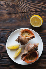 Glass plate with seafood julienne and lemon, above view