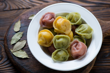 Close-up of a plate with three-colored meat dumplings or pelmeni