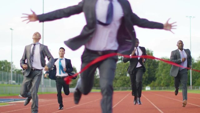  Group of competitive businessmen racing to the finish line at running track