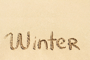 Word Winter handwritten on sand