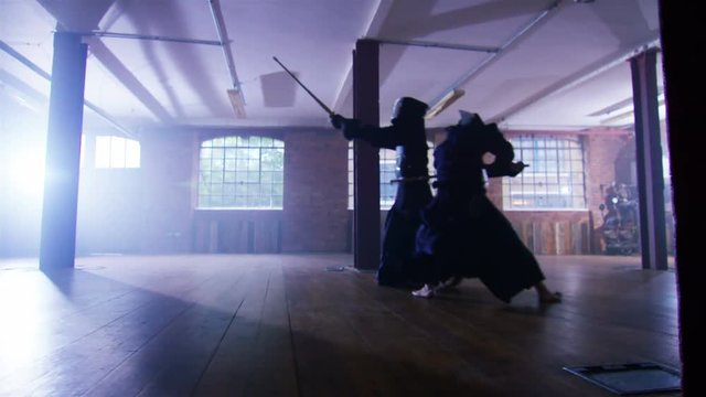  Japanese kendo fighters with bamboo swords competing in dark building