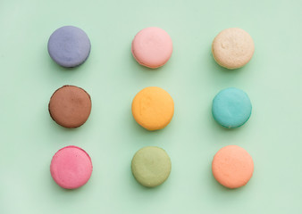 Sweet colorful French macaroon biscuits on pastel mint background