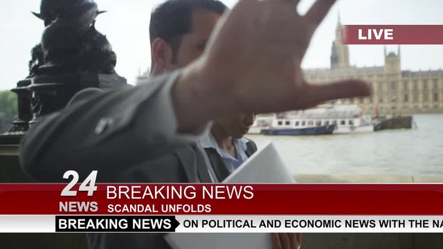  Couple in business dress in London being bothered by news reporter