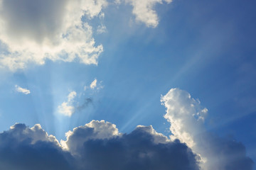 Fototapeta na wymiar sunbeam of sunlight through clouds on clear blue sky