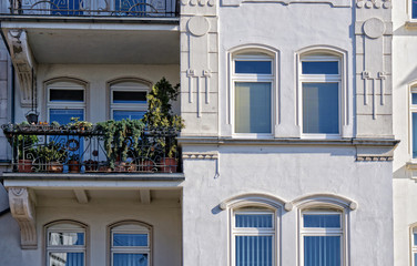 Fototapeta na wymiar wunderschöne Fassade eines Altbaus mit filigranen Stuckarbeiten und kleinem Balkon mit Balkonpflanzen 