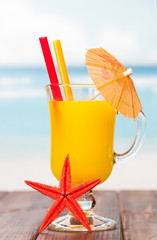 On the table there was a glass of orange juice 