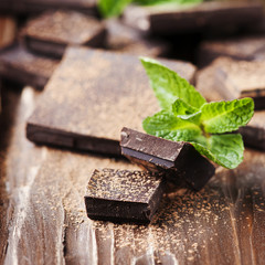 Dark chocolate and green mint on the wooden table