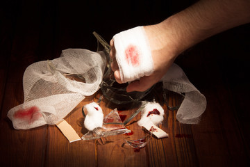 Man's hand chopped broken glass on the background  dark wood