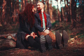 The red-haired guy with a beard and curly red-haired girl on the background of fabulous scenery of nature. Beautiful loving couple on a walk in the woods.