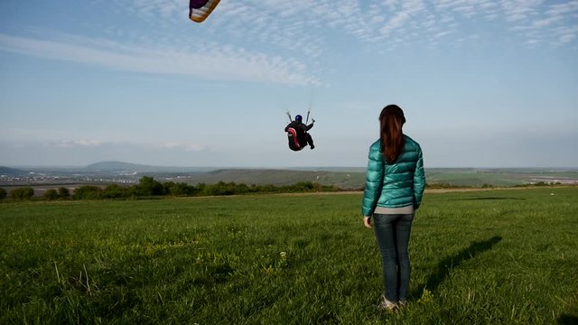 Woman and landing paraglider