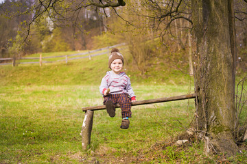 A little boy is sitting under a tree.