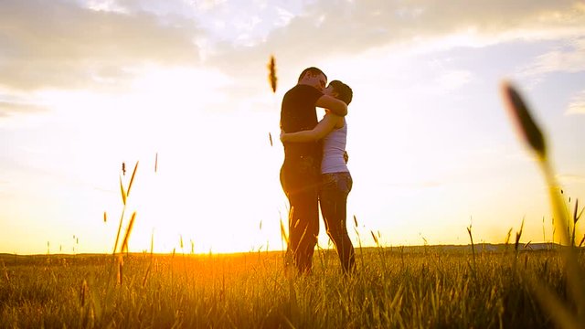 Lovers man and woman kiss on sunset fiery sun