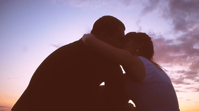 A man in love, kissing his beloved at sunset