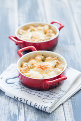 Fried eggs in red plates at wooden background