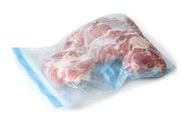 frozen raw pork wrapped in plastic bag on a white background