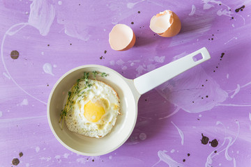 Fried eggs at lilac background