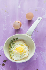 Fried eggs at lilac background