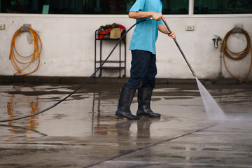 worker cleaning floor with air high pressure machine background