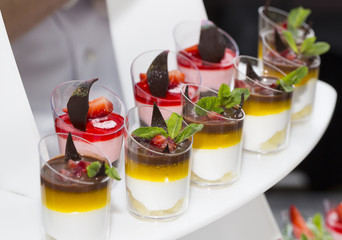 mini canapes in plastic cups decorated with edible flowers