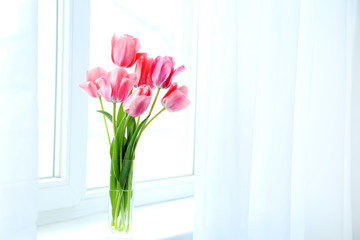 Pink tulips in vase on the windowsill