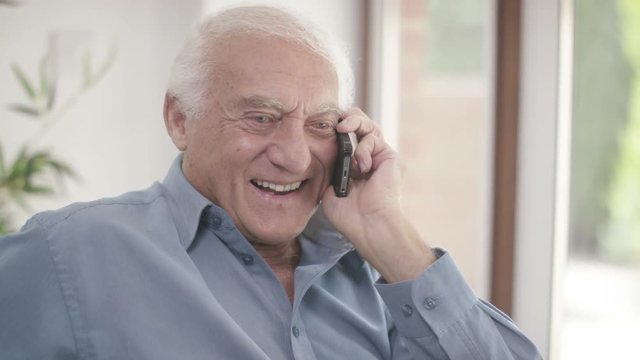  Elderly man in a wheelchair talking on mobile phone