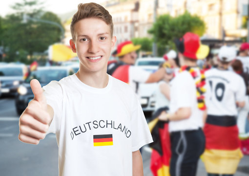 Lachender deutscher Fussball Fan zeigt Daumen beim Autocorso