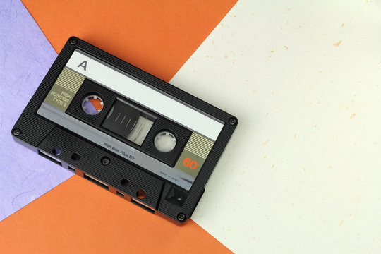 Audio Compact Cassette C60 tape with a blank label on a colored background