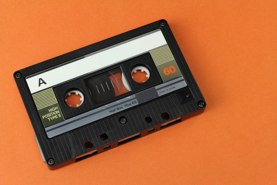 Audio Compact Cassette C60 tape with a blank label on a colored background