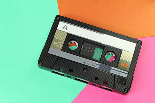 Audio Compact Cassette C60 tape with a blank label on a colored background