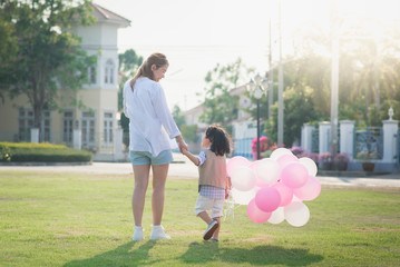 Asian mother and son holding hand together and walking