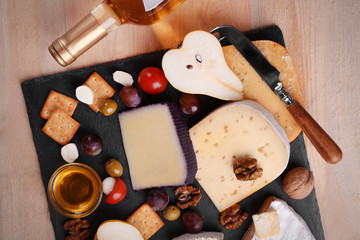 Different kinds of cheese on wooden background