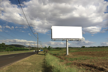 Billboard - Empty billboard in front of beautiful cloudy sky in a rural location - obrazy, fototapety, plakaty