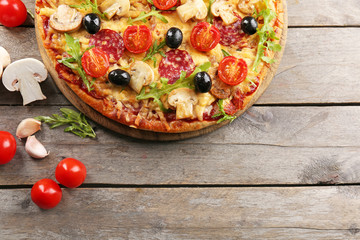 Delicious tasty pizza with ingredients on wooden table